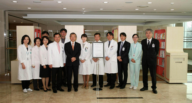 암병원 2층 휴게홀 서가 앞에서 정희원 서울대학교병원장[왼쪽에서 7번째], 김승협 진료부원장[맨 오른쪽], 노동영 암병원장[왼쪽에서 5번째] 등이 책 읽는 서가 운영 기념 단체사진을 찍고 있다. 